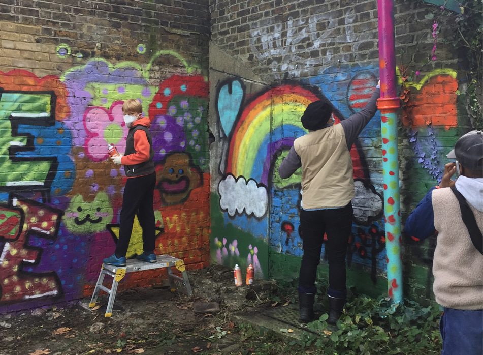 Volunteers painting Clitterhouse Farm community wall